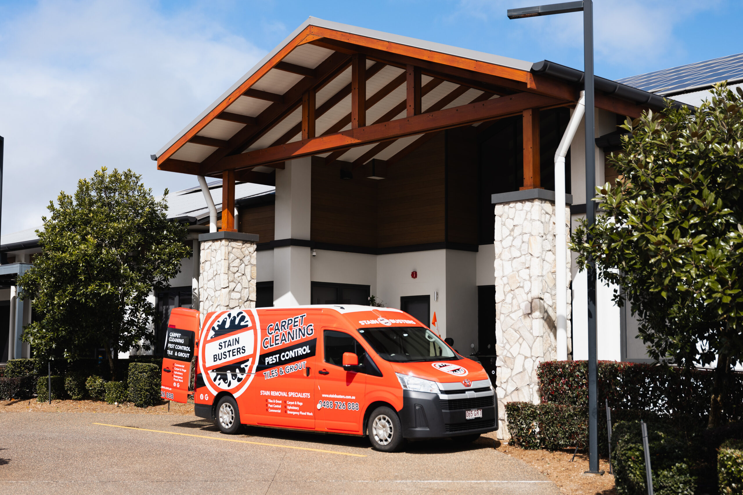 Stain Busters branded vehicle in front of a commercial cleaning client building