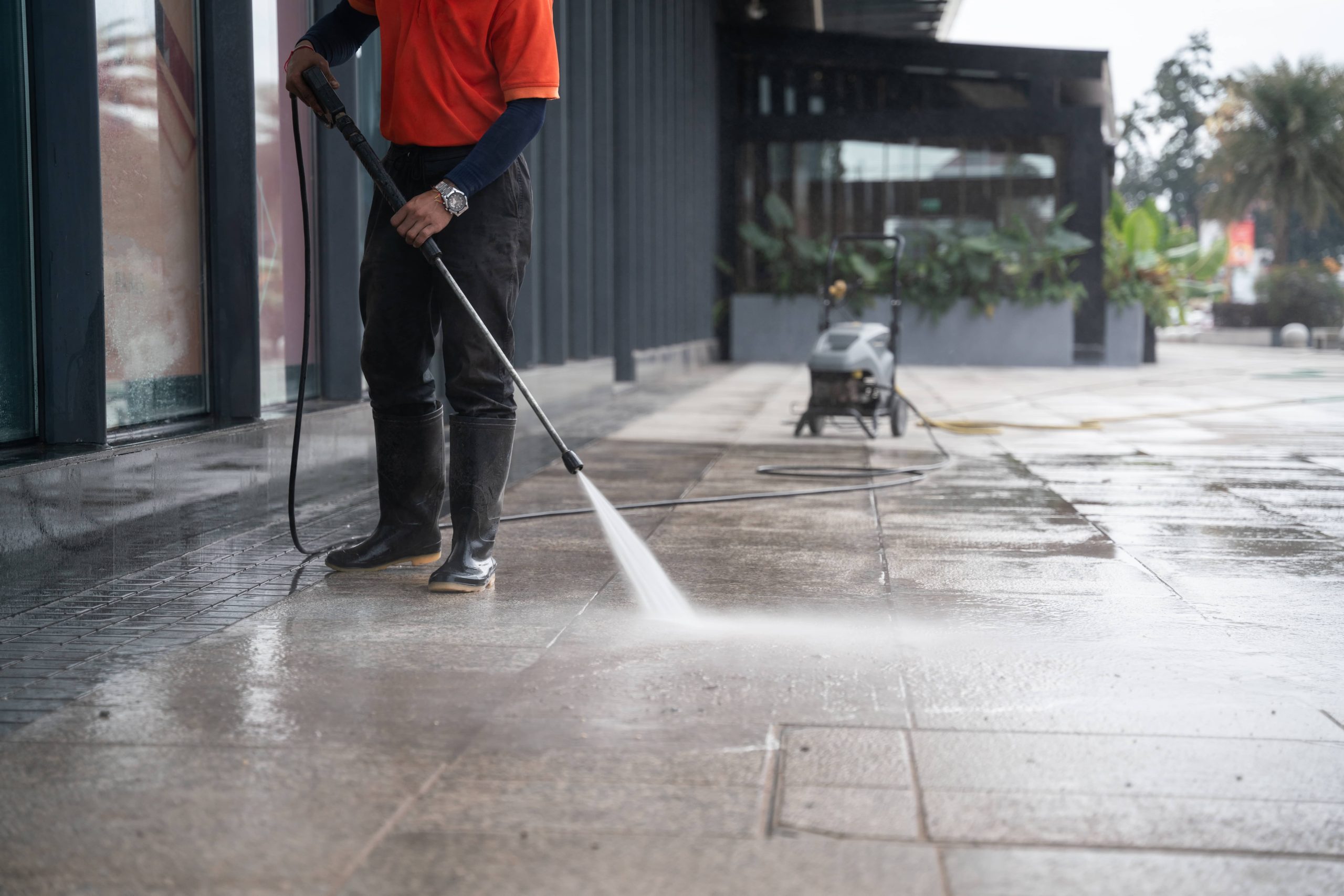 person pressure washing outdoor pavement