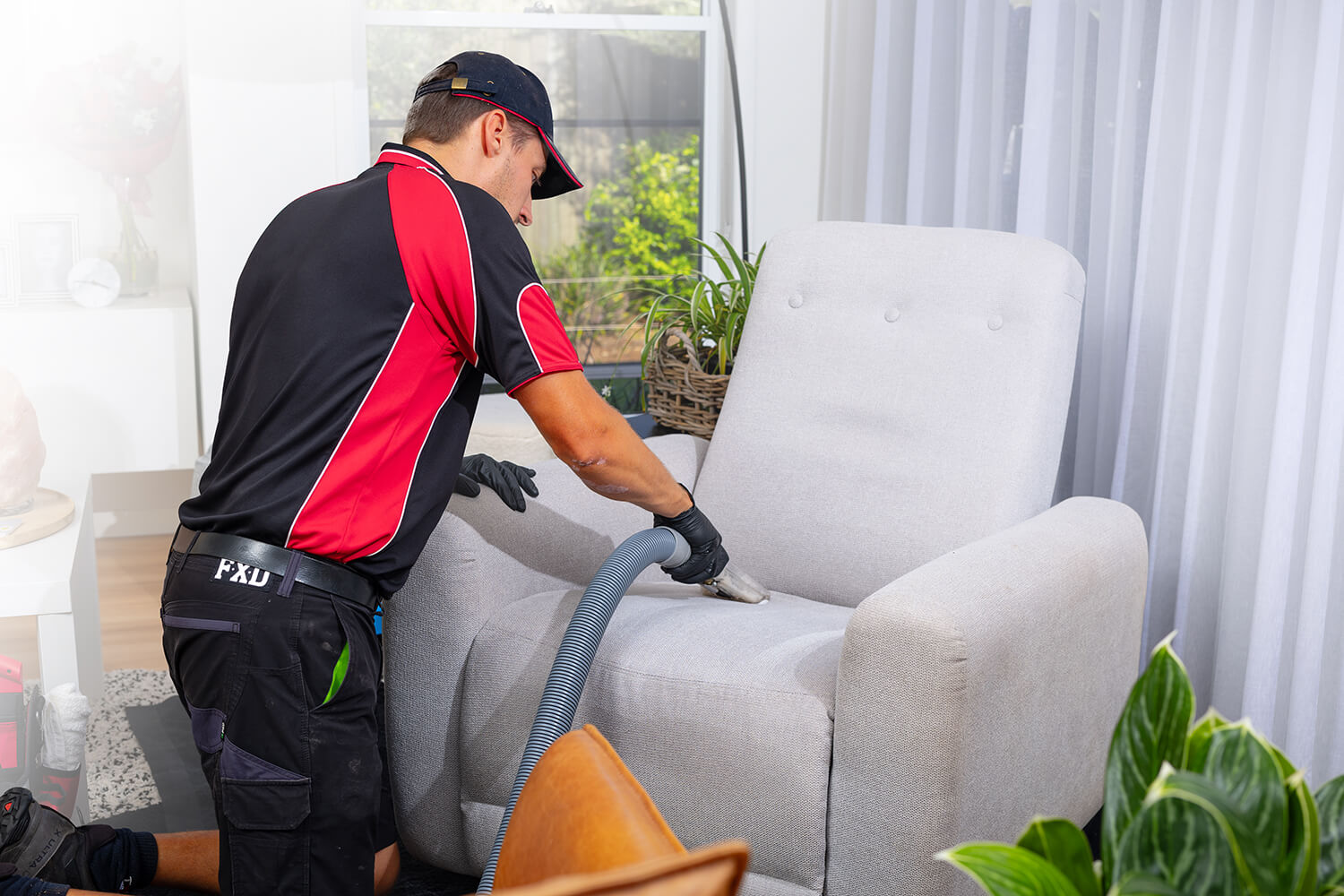 A Stain Busters professional cleaning an upholstered chair