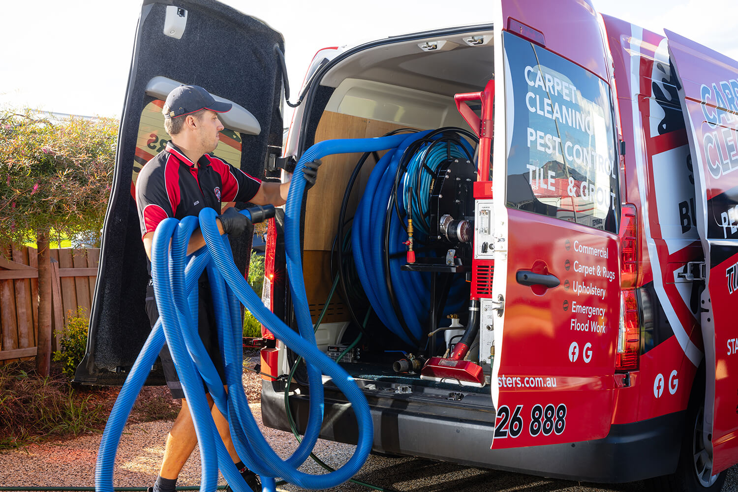 One of our pest control professionals pulling a hose out of their van